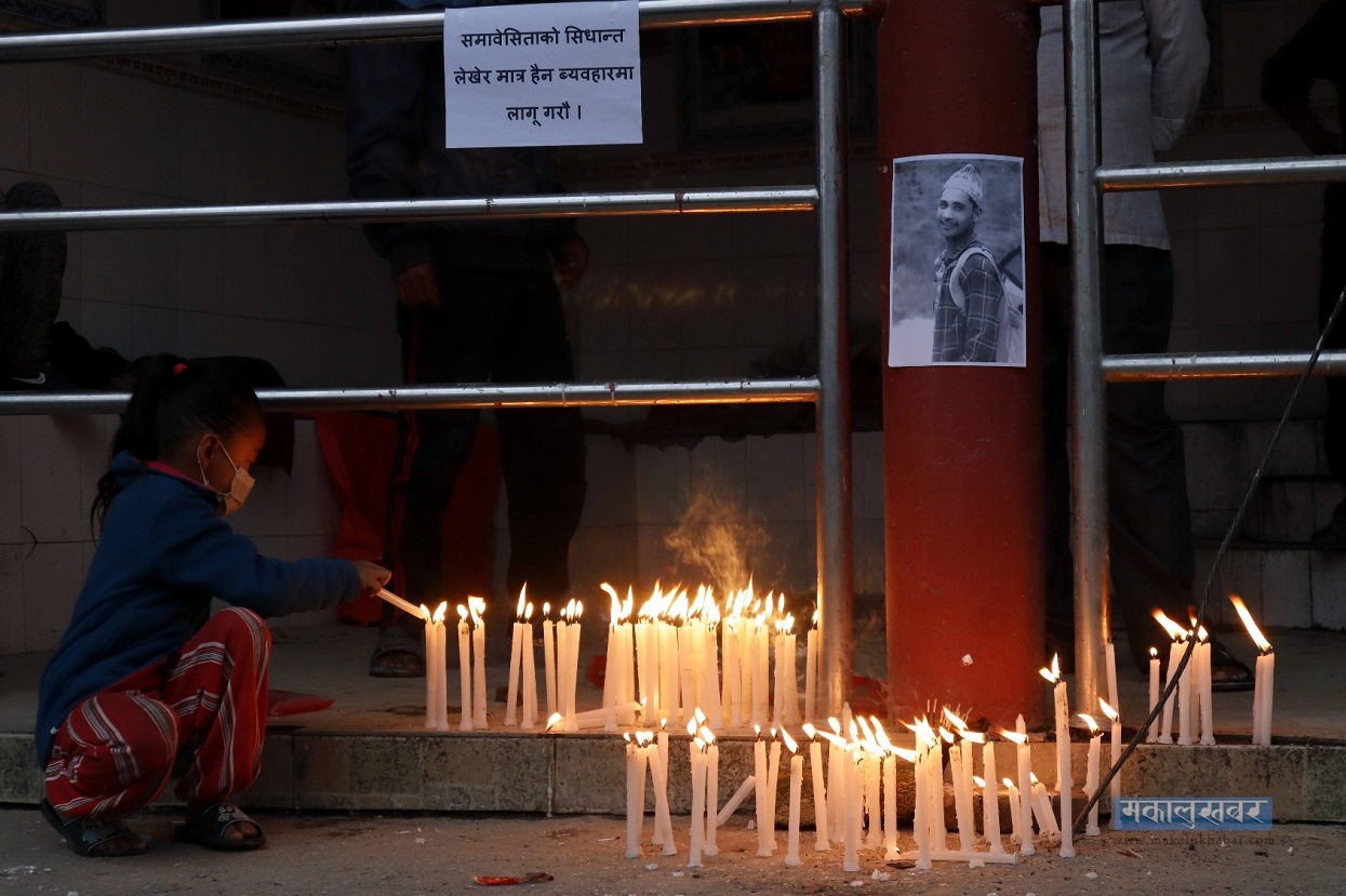 Girl lighting a lamp in memory of Nawaraj BK.